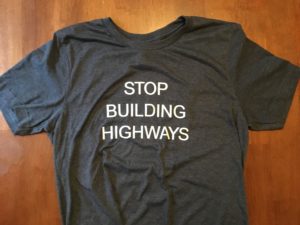front of tee shirt with text "STOP BUILDING HIGHWAYS" in all caps